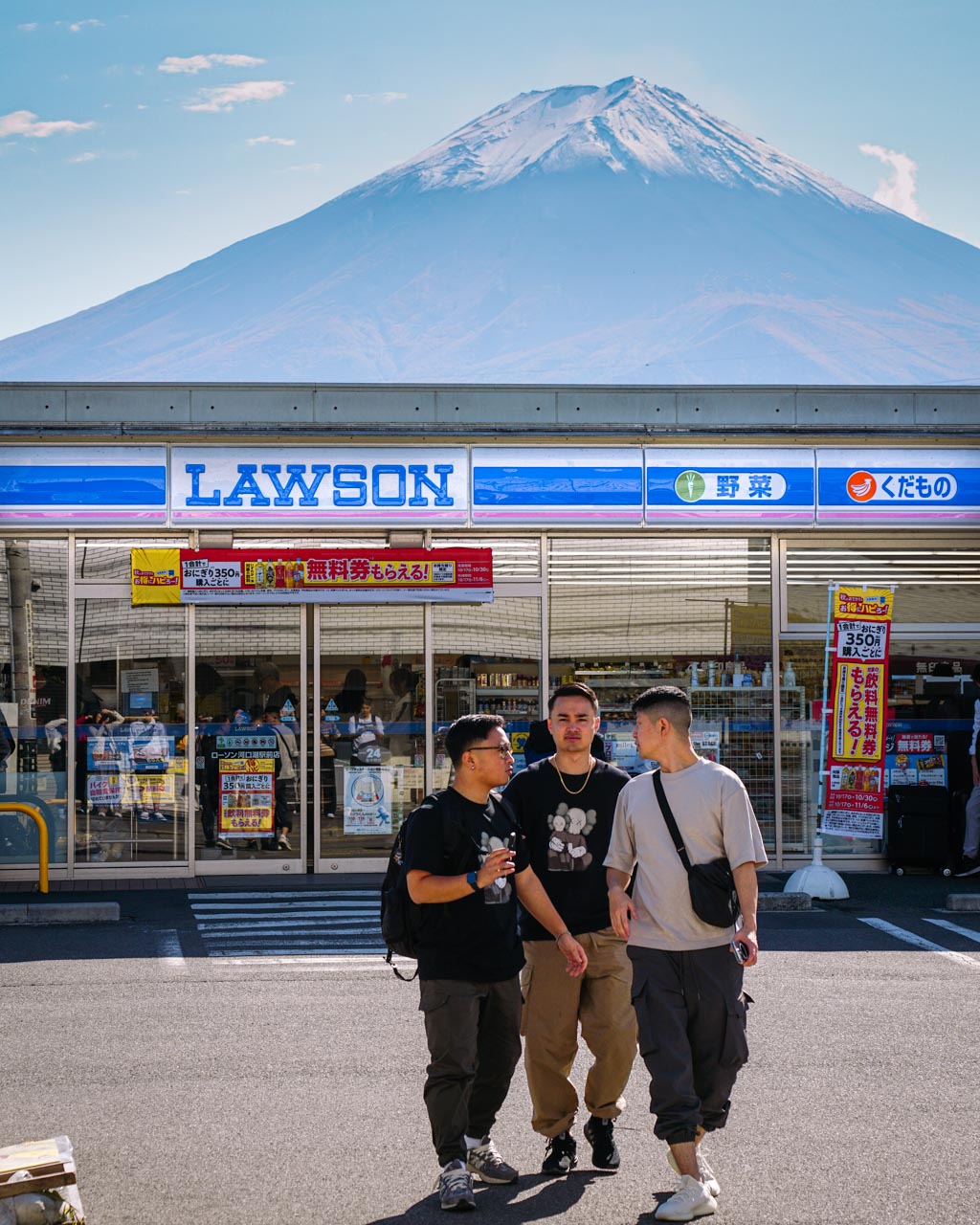 A group of friends infront of a convenience store infront of Mount Fuji