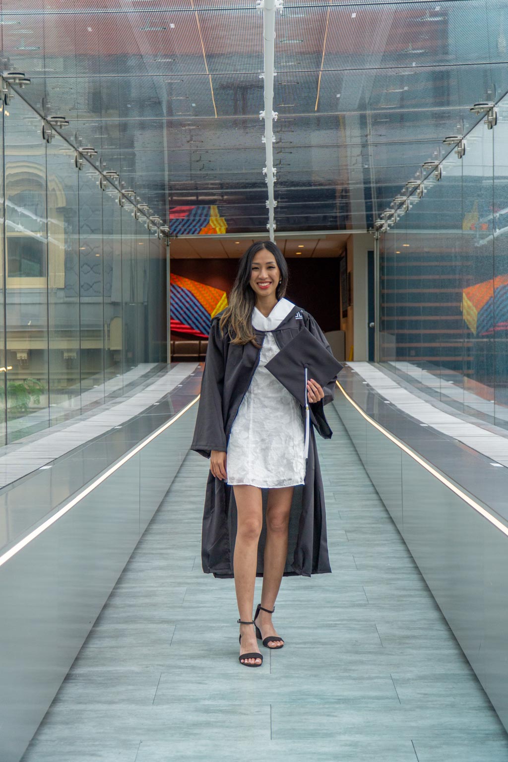 A college graduate posing in her gown and cap