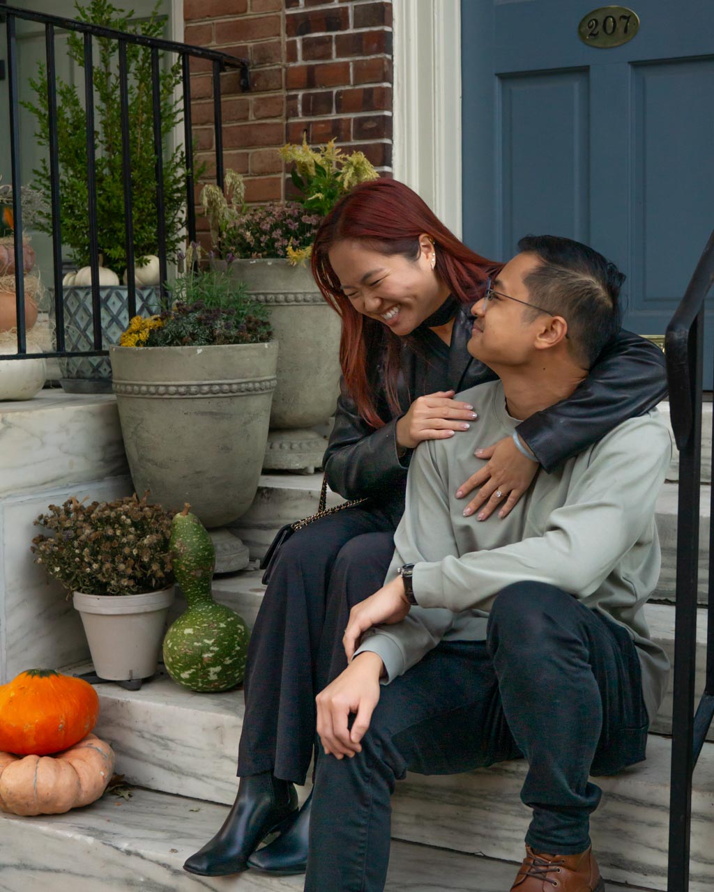 A newly engaged couple sitting on a rowhouse stoop