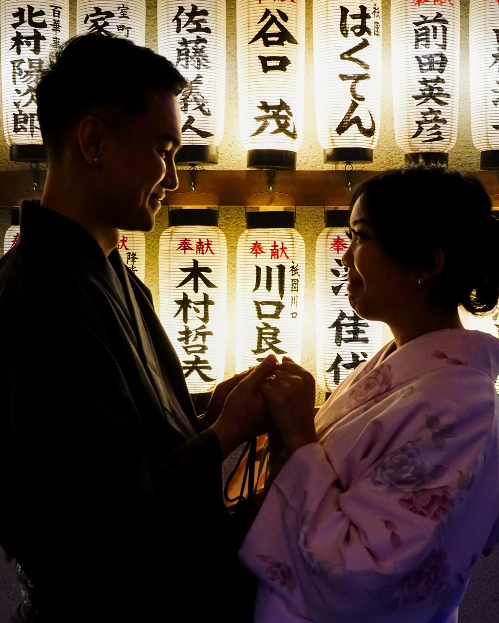 A dramatic silhouette shot of a couple with lanterns behind them