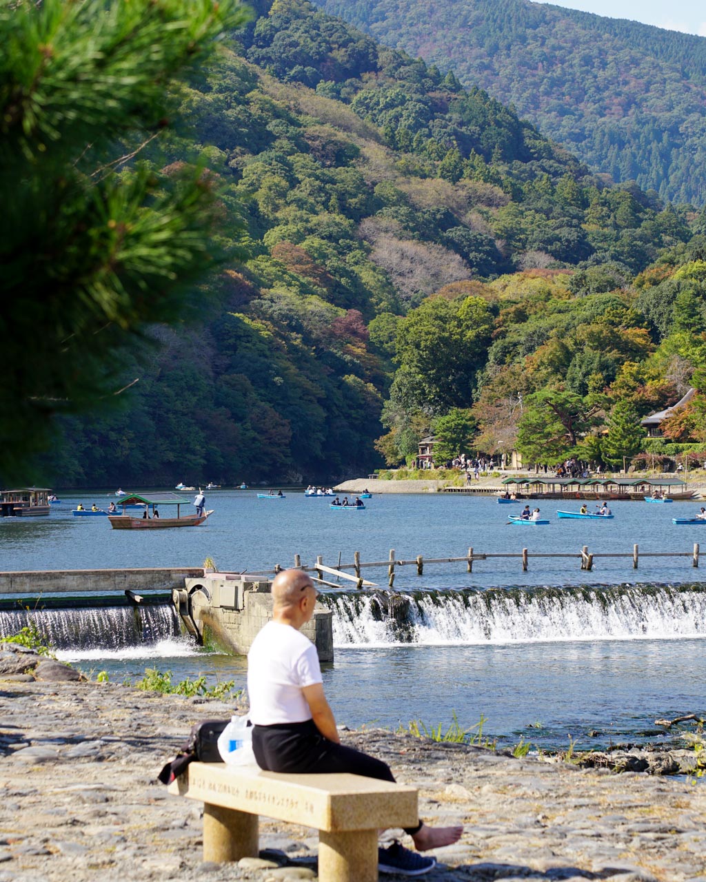 A senior man relaxing on a bench by a lake