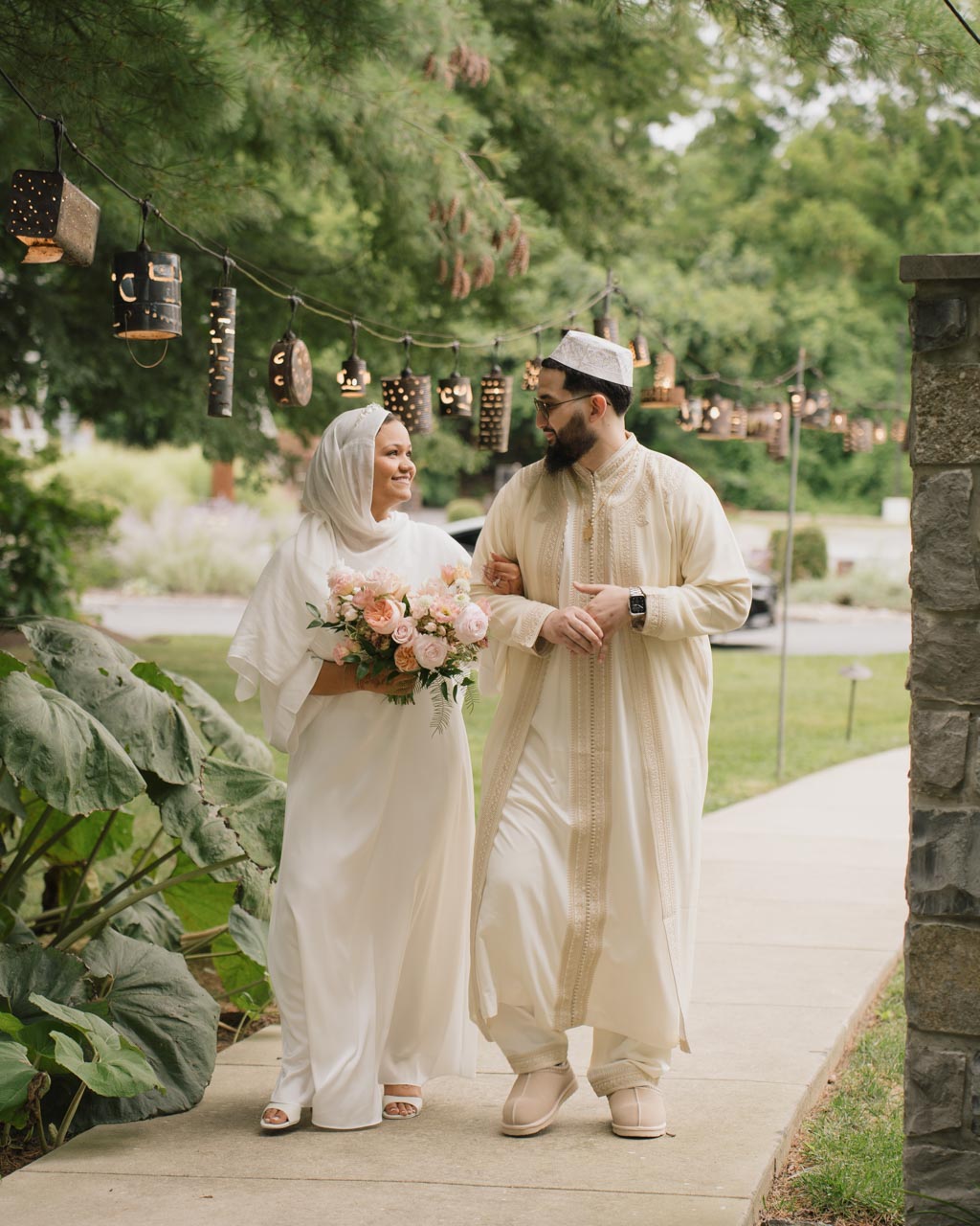 A wedded couple walking together on a romantic paved path