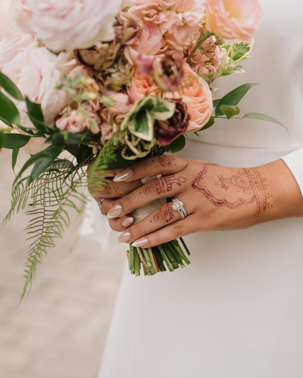 A close up shot of the bride's ring while holding bouquet
